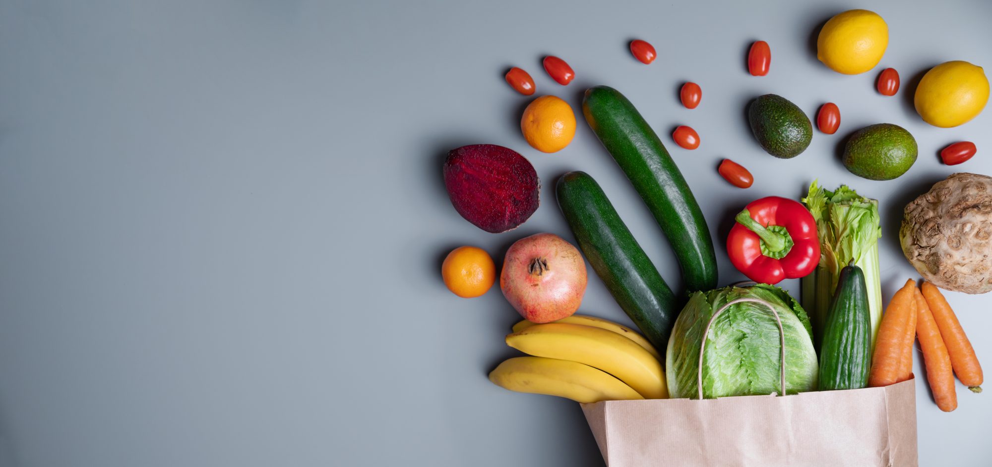 Bag of healthy vegetables on a gray background with copy space. Online shop concept in a natural light